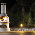 Buschbeck outdoor fireplace lit on a dark winter evening.